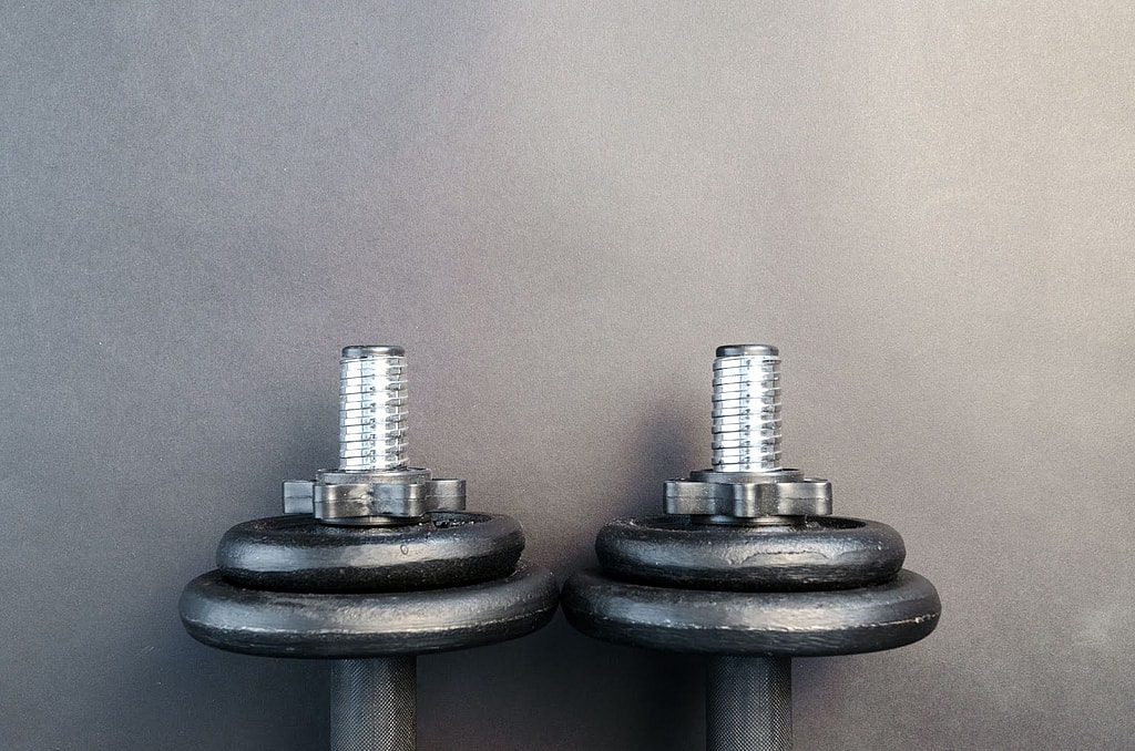 A pair of dumbbell weights resting on a wall