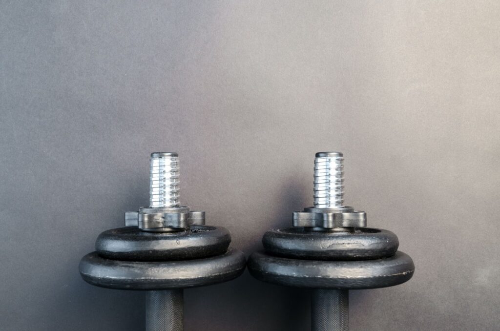 A pair of dumbbell weights resting on a wall